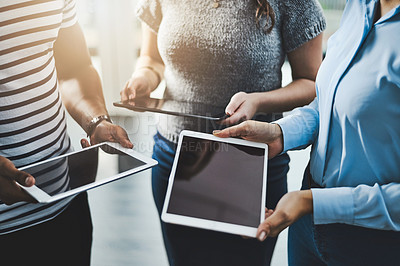 Buy stock photo Closeup shot of a group of businesspeople using digital tablets in an office