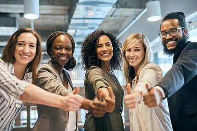 Buy stock photo Portrait of a group of cheerful young businesspeople showing thumbs up inside of the office at work during the day