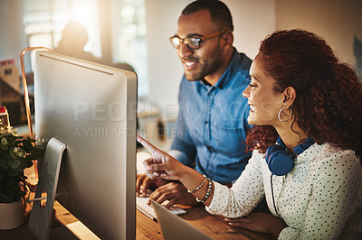 Buy stock photo Shot of a young businessman and businesswoman using a computer together during a late night at work