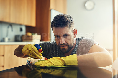 Buy stock photo Shot of a young man cleaning the kitchen counter at home