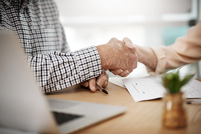 Buy stock photo Cropped shot of an unrecognizable senior couple shaking hands while working on their finances at home