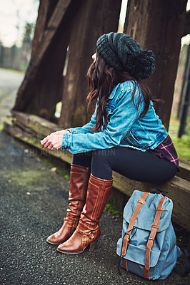 Buy stock photo Shot of a young woman sitting outdoors