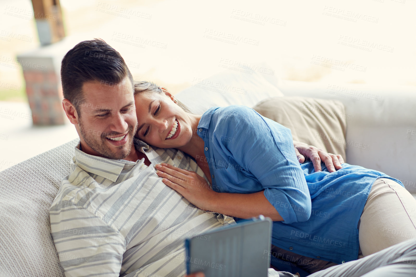 Buy stock photo Cropped shot of a young married couple taking a selfie using a tablet on the sofa at home