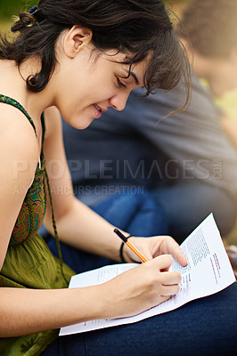 Buy stock photo Cropped shot of a young female college student doing an assignment outside