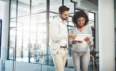 Buy stock photo Shot of two businesspeople discussing something on a digital tablet