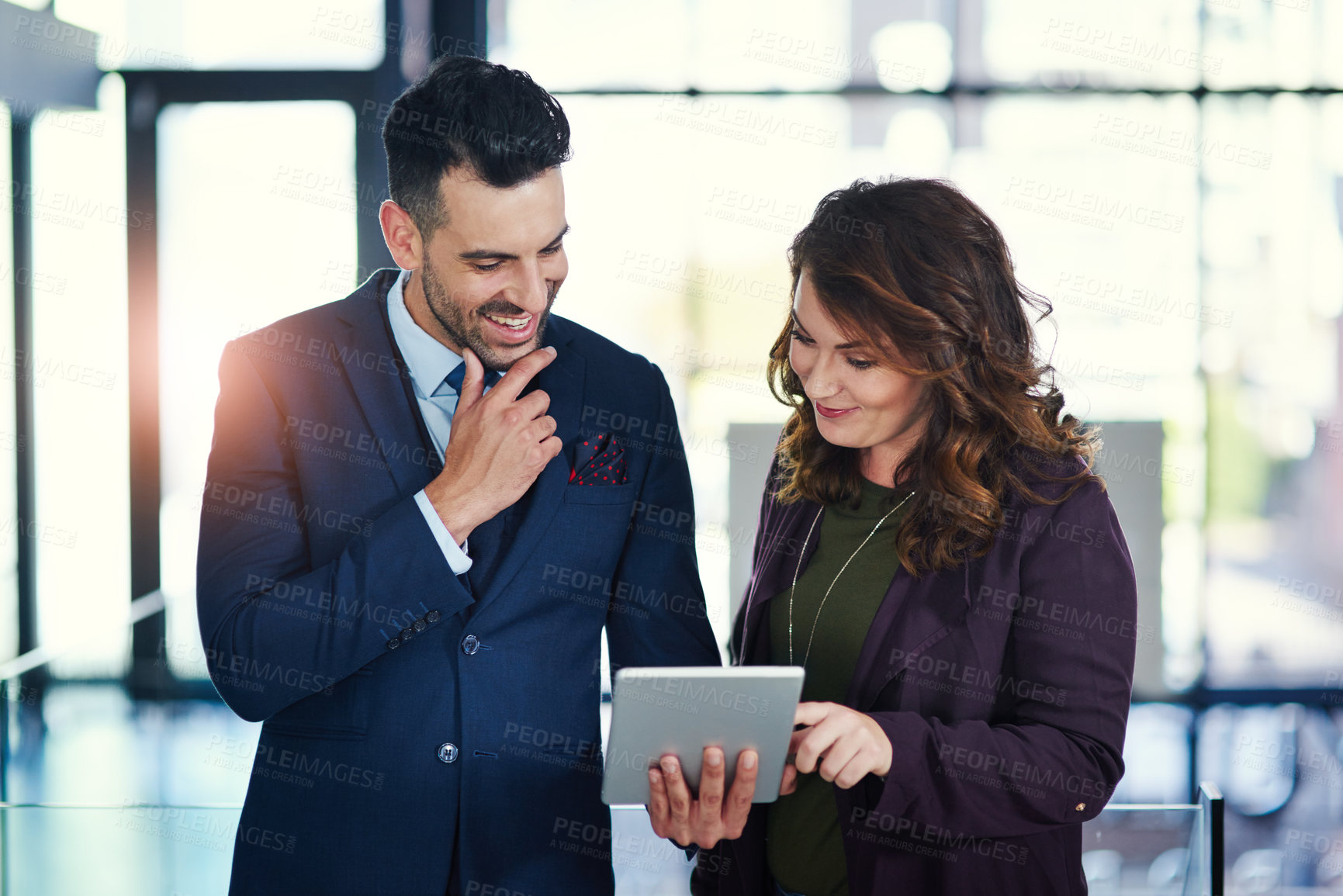 Buy stock photo Shot of two businesspeople using a digital tablet together in an office