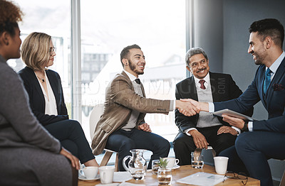 Buy stock photo Shot of businesspeople shaking hands during a meeting in an office