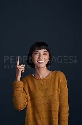 Buy stock photo Woman in portrait, pointing up with advertising and mockup space, smile and promo isolated on dark background. Happy female person, ambassador and branding with marketing and presentation in studio
