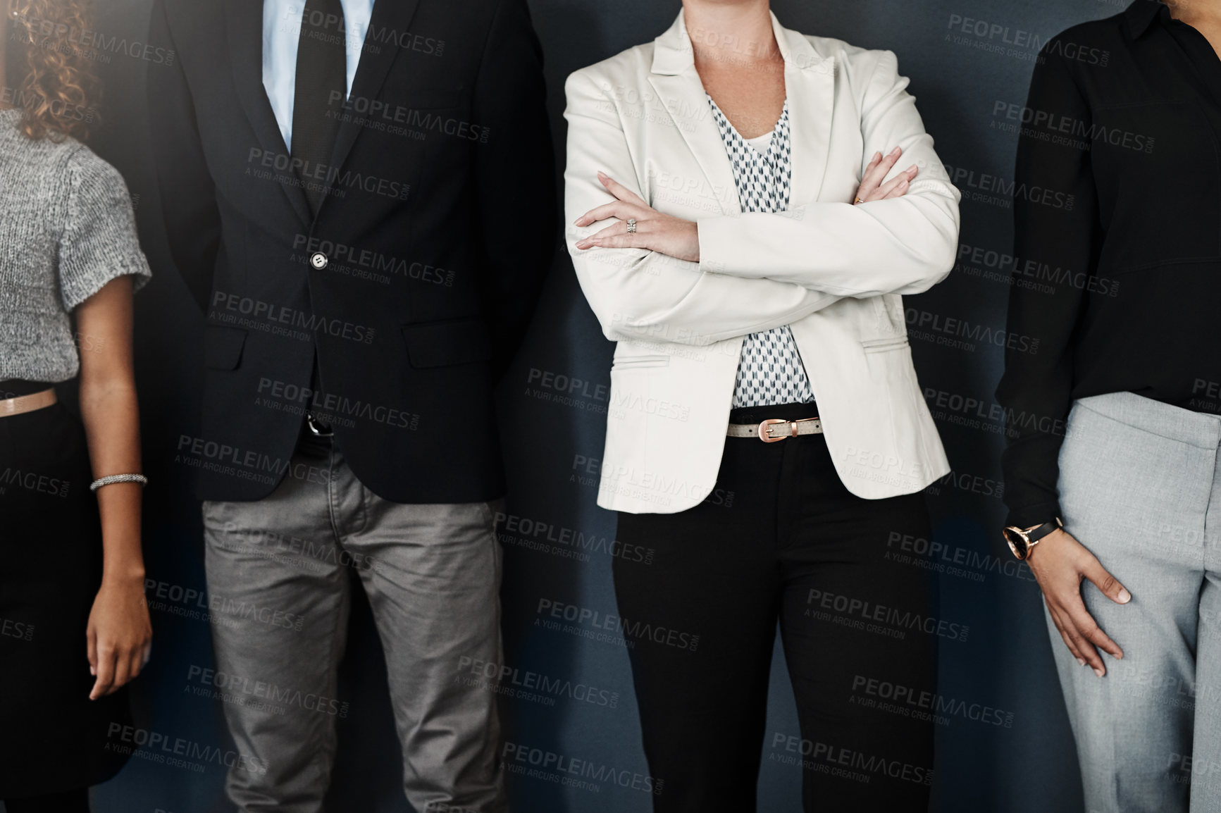 Buy stock photo Studio shot of a group of unrecognizable businesspeople posing against a dark background
