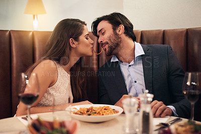 Buy stock photo Love, kiss and spaghetti with couple in restaurant sharing for romance, valentines day and date. Bonding, smile and celebration with man and woman with pasta at table for fine dining, wine and cute