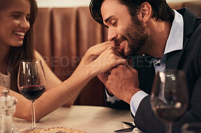 Buy stock photo Hand, kiss and date with a couple in a restaurant on a night out together for love, fine dining or luxury. Anniversary, romance and affection with a man kissing his wife while dating in celebration