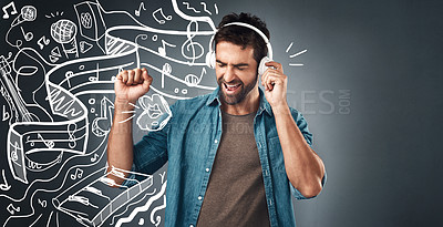 Buy stock photo Studio shot of a handsome young man listening to music while standing beside illustrations against a grey background