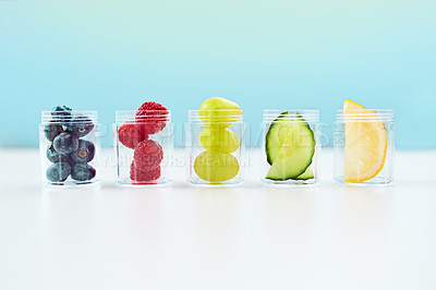 Buy stock photo Studio shot of a conceptual image of natural medication lined up on a table against a blue background