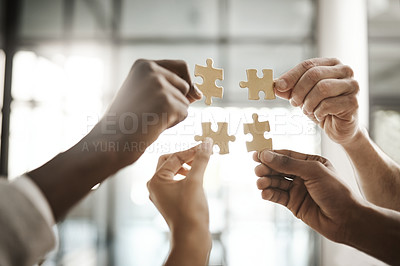 Buy stock photo Diverse team solving a problem together due to teamwork, support and helping each other in the office. Group of business people assembling a puzzle and collaborating in unity