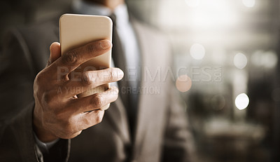 Buy stock photo Cropped shot of an unrecognizable businessperson browsing on a cellphone inside of the office during the day