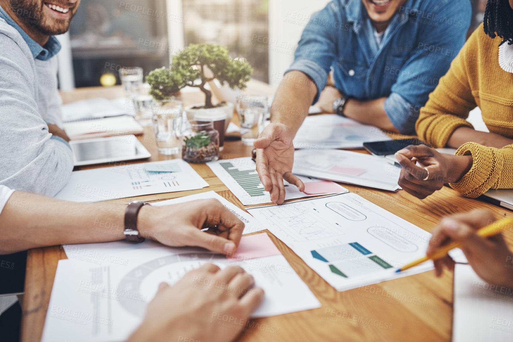 Buy stock photo High angle shot of a group of unrecognizable businesspeople discussing statistics