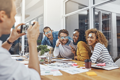 Buy stock photo Silly, notes and eyes of business people in meeting with staff picture for social media in office. Employee, smile and creative employees with comedy, team building and fun in boardroom with photo