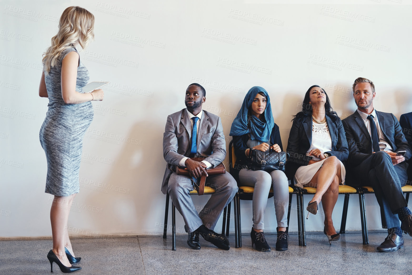 Buy stock photo Shot of a group of confident businesspeople waiting in line for their interviews inside of a office during the day