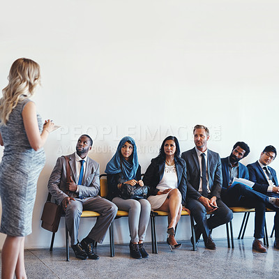 Buy stock photo Shot of a group of confident businesspeople waiting in line for their interviews inside of a office during the day