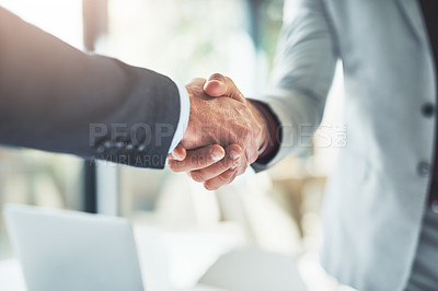 Buy stock photo Cropped shot of two unrecognizable businessmen shaking hands after making a deal in the office