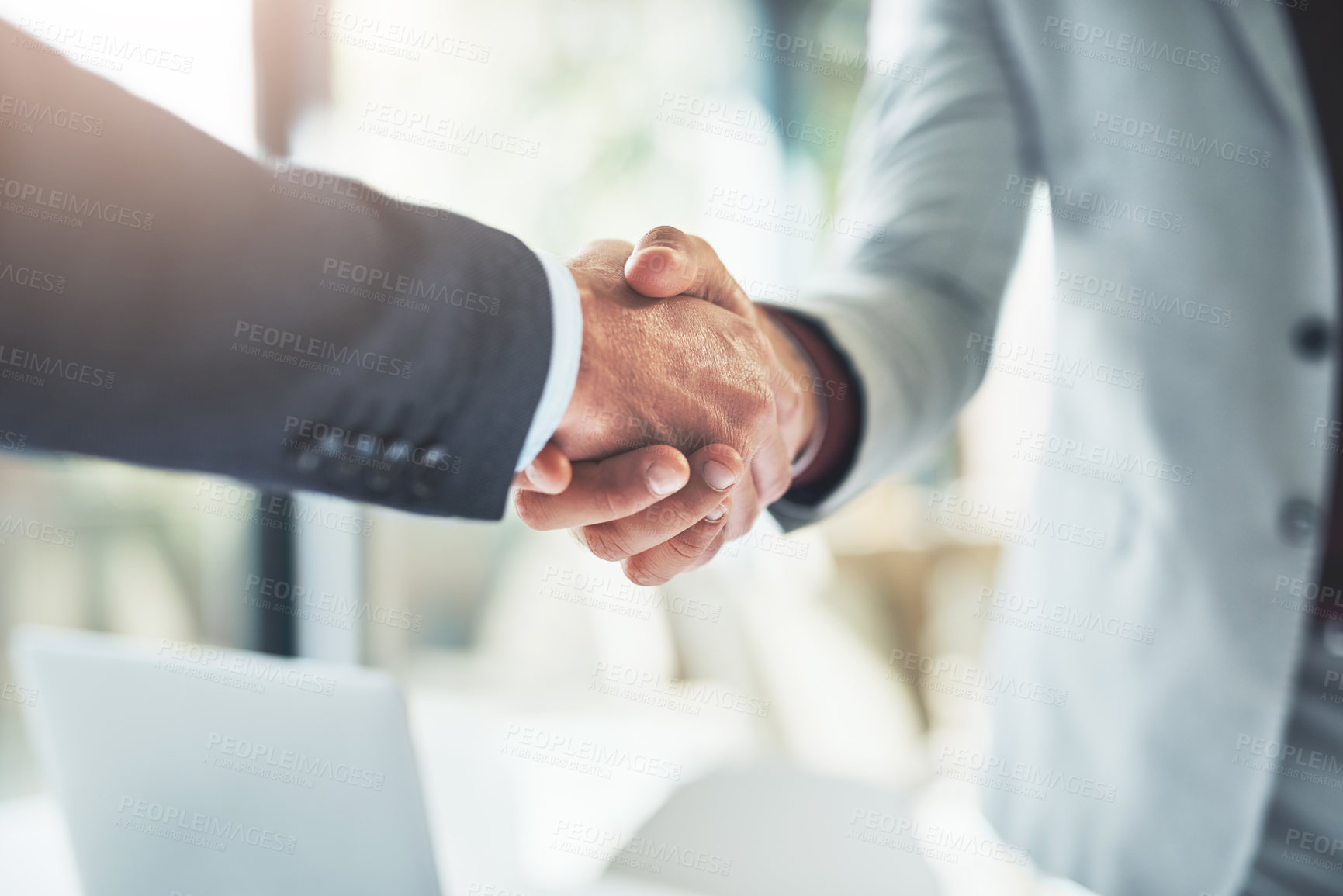 Buy stock photo Cropped shot of two unrecognizable businessmen shaking hands after making a deal in the office