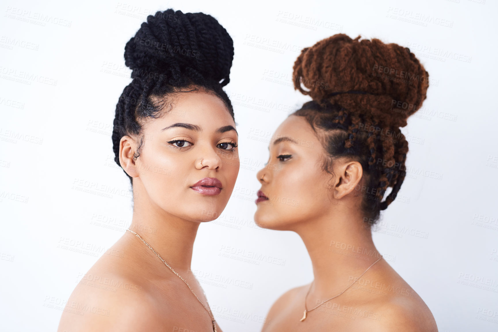 Buy stock photo Studio shot of two beautiful young women posing against a grey background