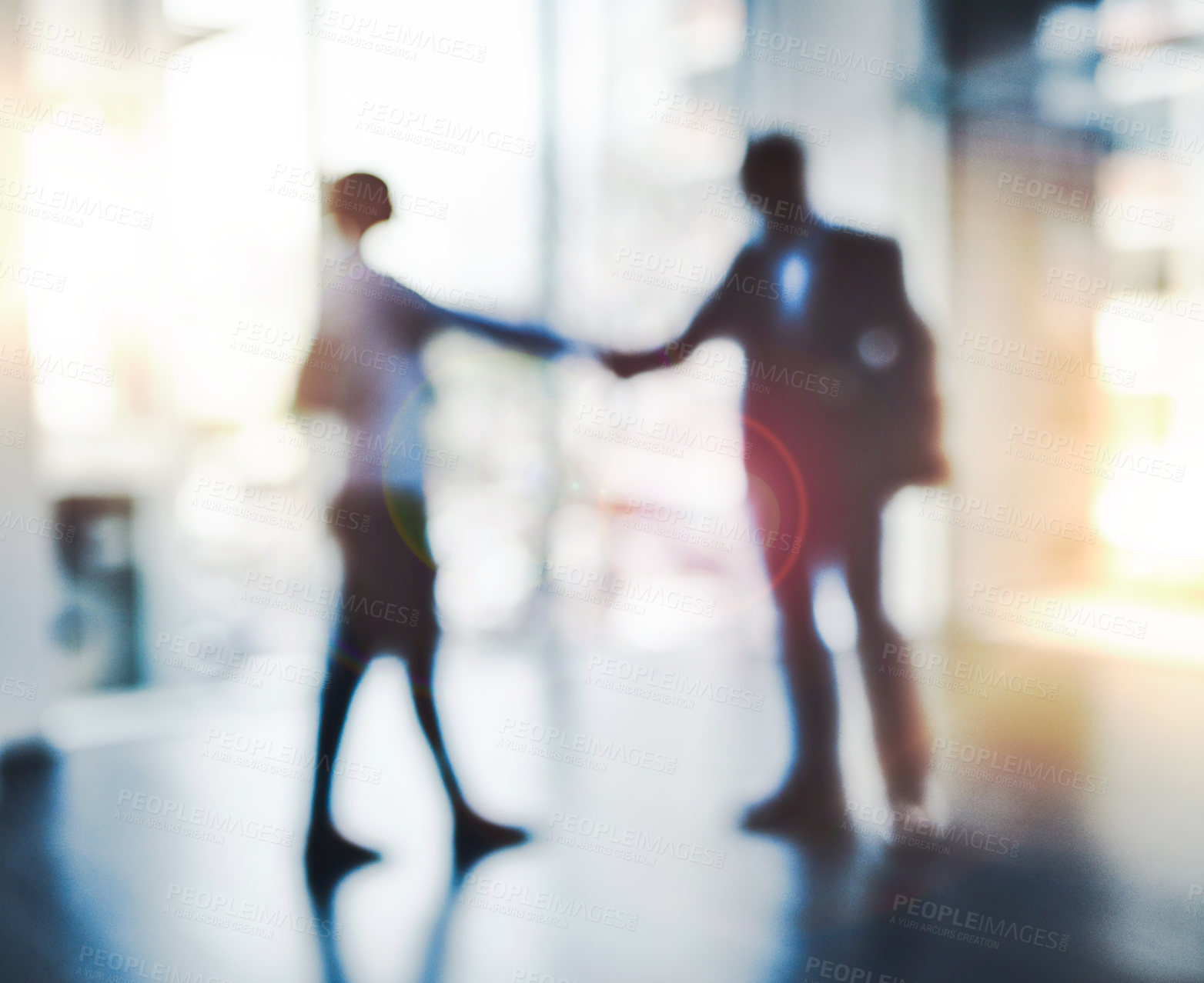 Buy stock photo Defocused shot of two businesspeople shaking hands in an office