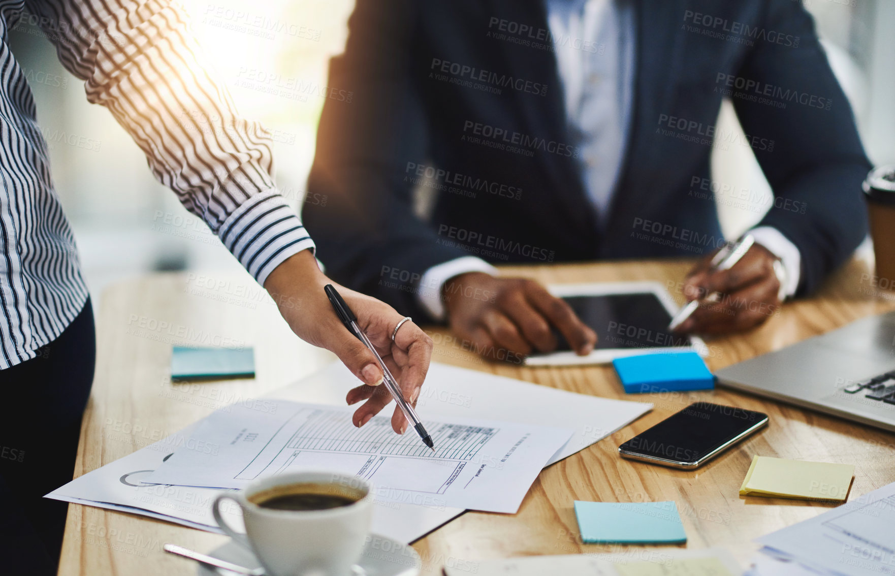 Buy stock photo Closeup shot of two businesspeople going through paperwork in an office