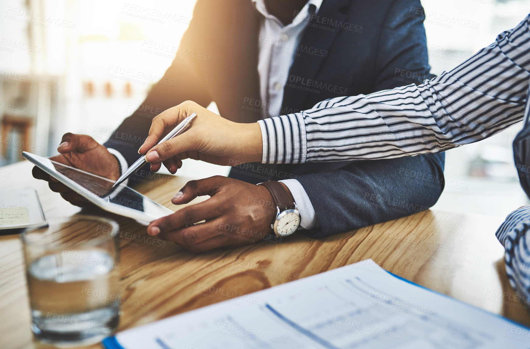 Buy stock photo Closeup shot of two businesspeople working together on a digital tablet in an office