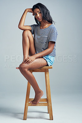 Buy stock photo Portrait, fashion and girl on wooden stool, relax and casual outfit on a grey studio background. Face, Indian person and model with stylish outfit and gen z with teenager on chair with break or rest