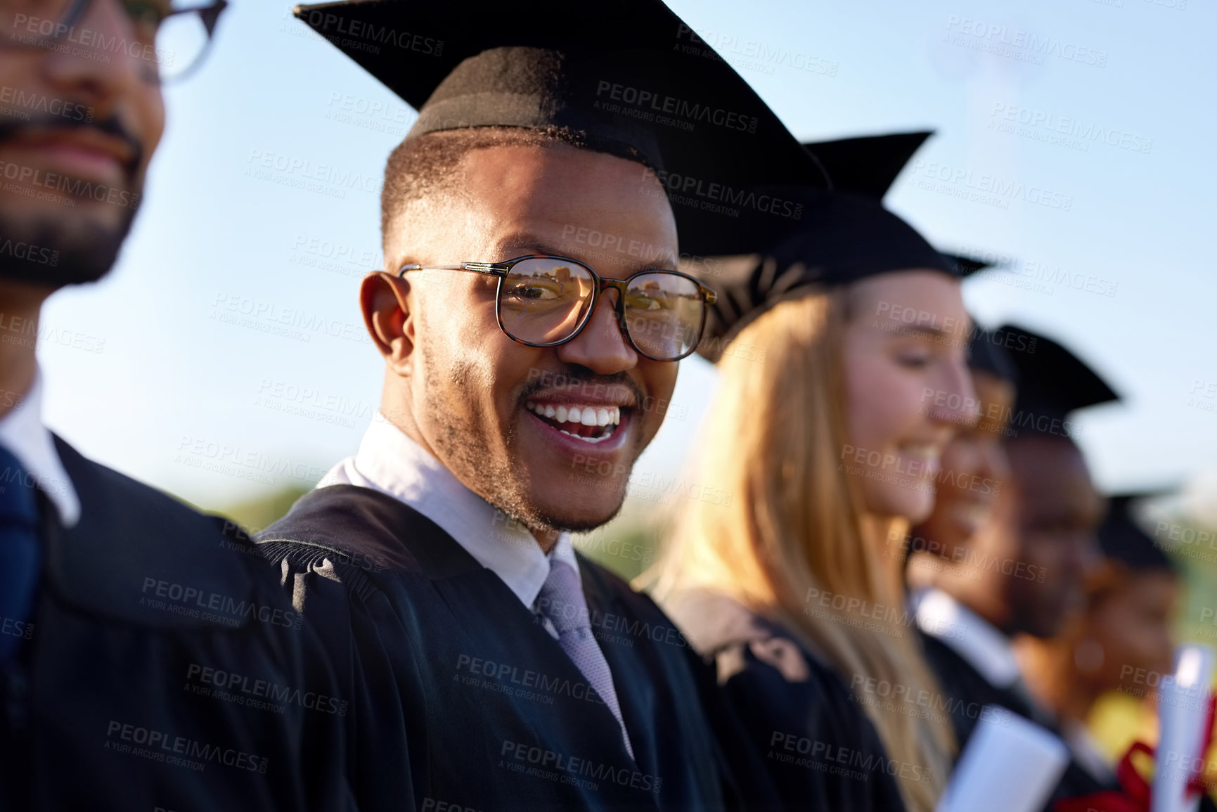 Buy stock photo Black man, student portrait and graduation class with group at ceremony for education, qualification or future. Happy person or scholar with smile for diploma, certificate or degree on campus