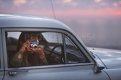 Buy stock photo Shot of a young woman taking pictures while out on a road trip