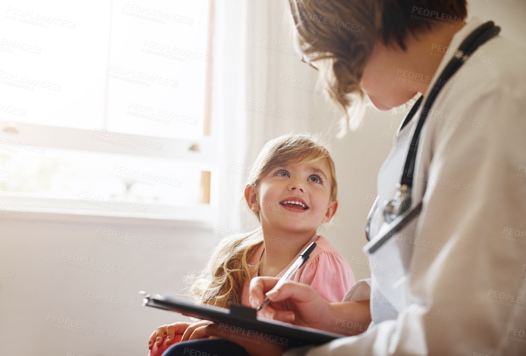 Buy stock photo Child doctor, girl and talking trust with medical checklist in a hospital for wellness and health. Happiness, clinic consultant and pediatrician with healthcare and appointment with a kid form