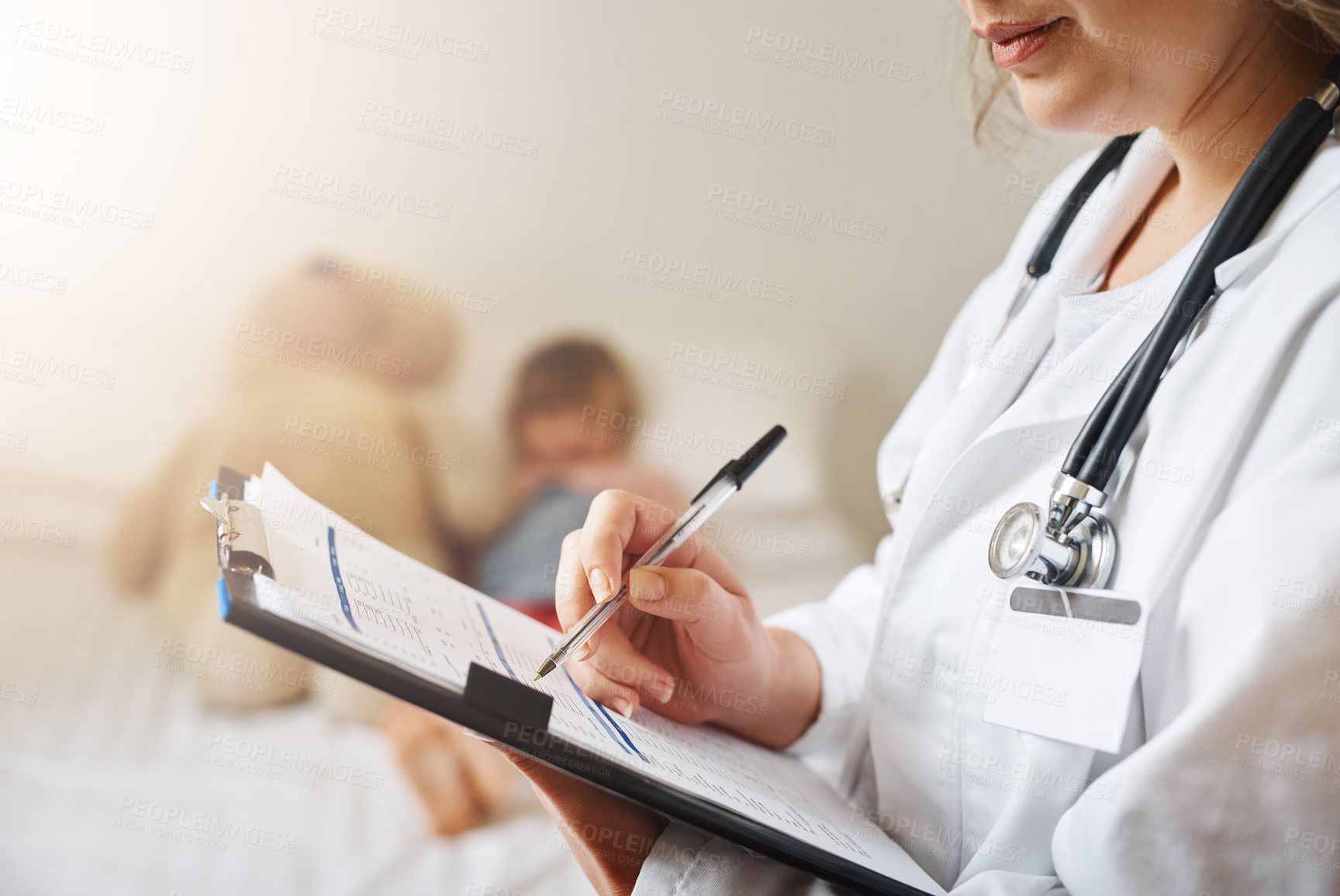 Buy stock photo Cropped shot of a doctor filling out a form while treating a patient