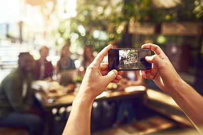 Buy stock photo Cropped shot of an unrecognizable man taking a picture of friends out for lunch