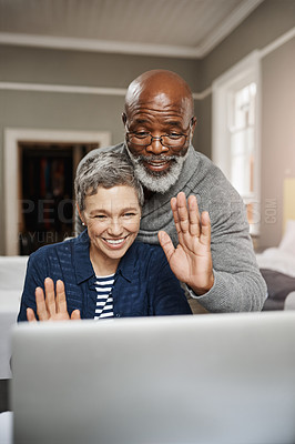 Buy stock photo Shot of a senior couple waving while using a laptop at home
