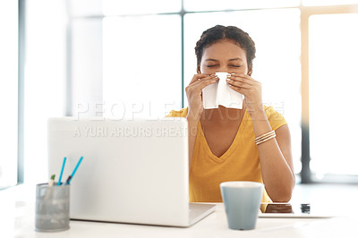 Buy stock photo Shot of a young businesswoman blowing her nose at her desk in a modern office