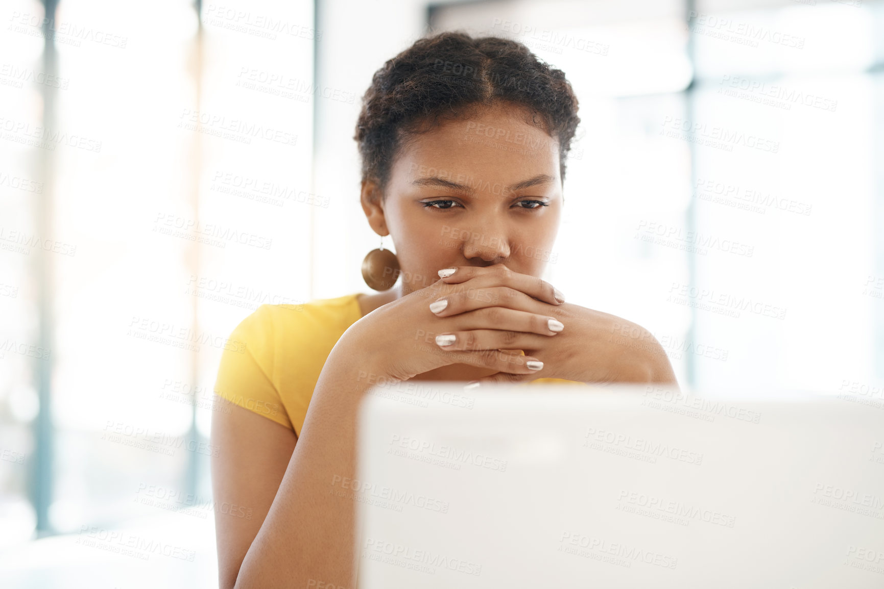 Buy stock photo Shot of a young businesswoman using a laptop at her desk in a modern office