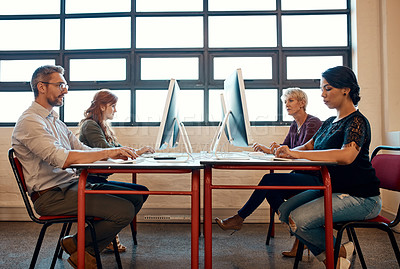 Buy stock photo Shot of a group of businesspeople working on computers in a modern office