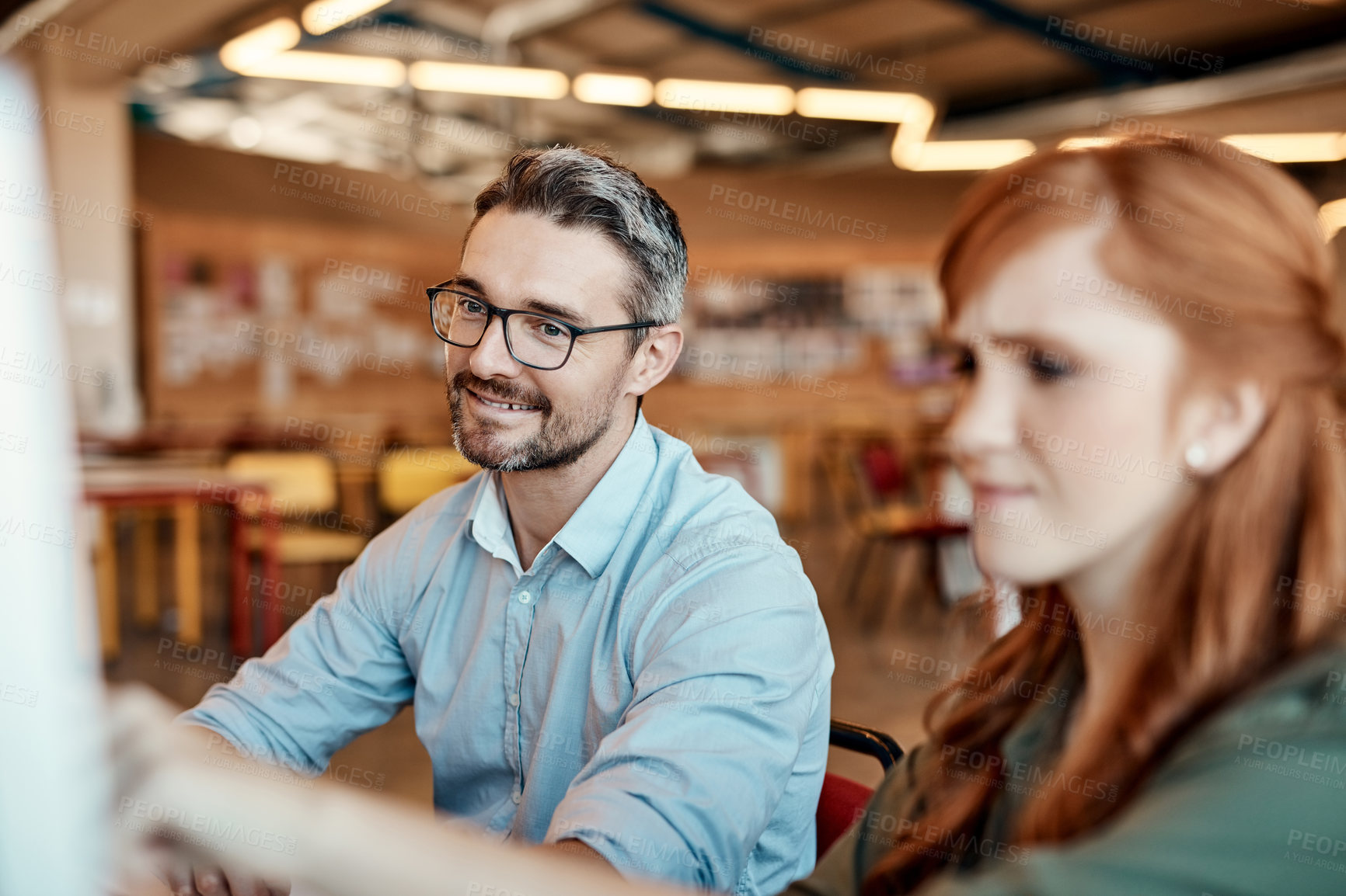 Buy stock photo Shot of a young businesswoman and mature businessman using a computer together in a modern office