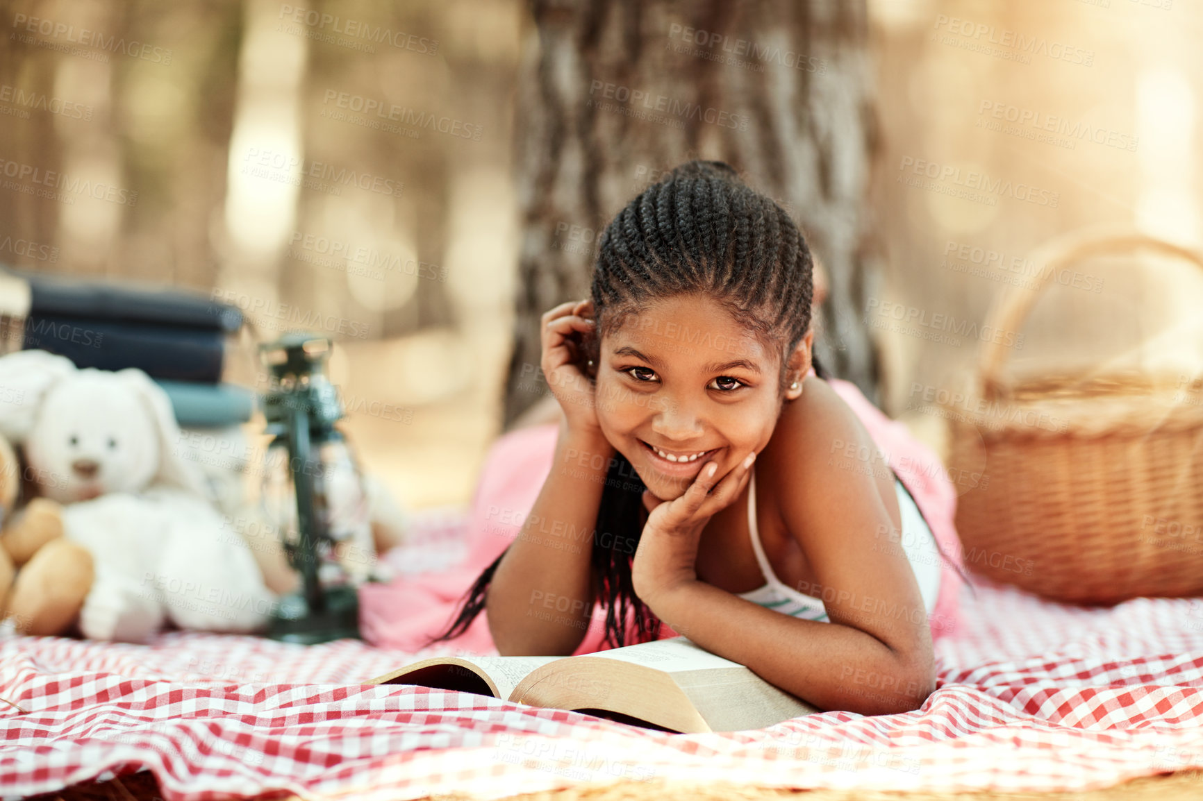 Buy stock photo Portrait of a little girl reading a book with her toys in the woods