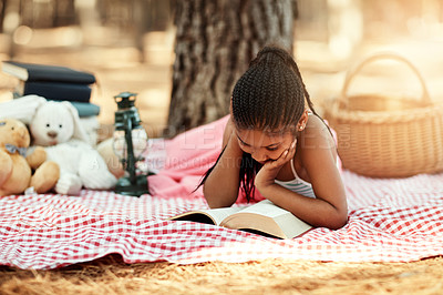 Buy stock photo Shot of a little girl reading a book with her toys in the woods