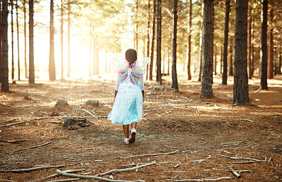 Buy stock photo Rear view shot of a little girl walking in the woods while dressed up as a fairy