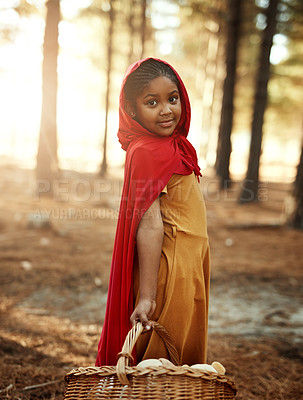 Buy stock photo Kid, red and basket in forest for portrait, adventure and fairytale fantasy in nature. Girl, hamper and hood in woods for story themed birthday party, magic and cosplay at trees with creativity