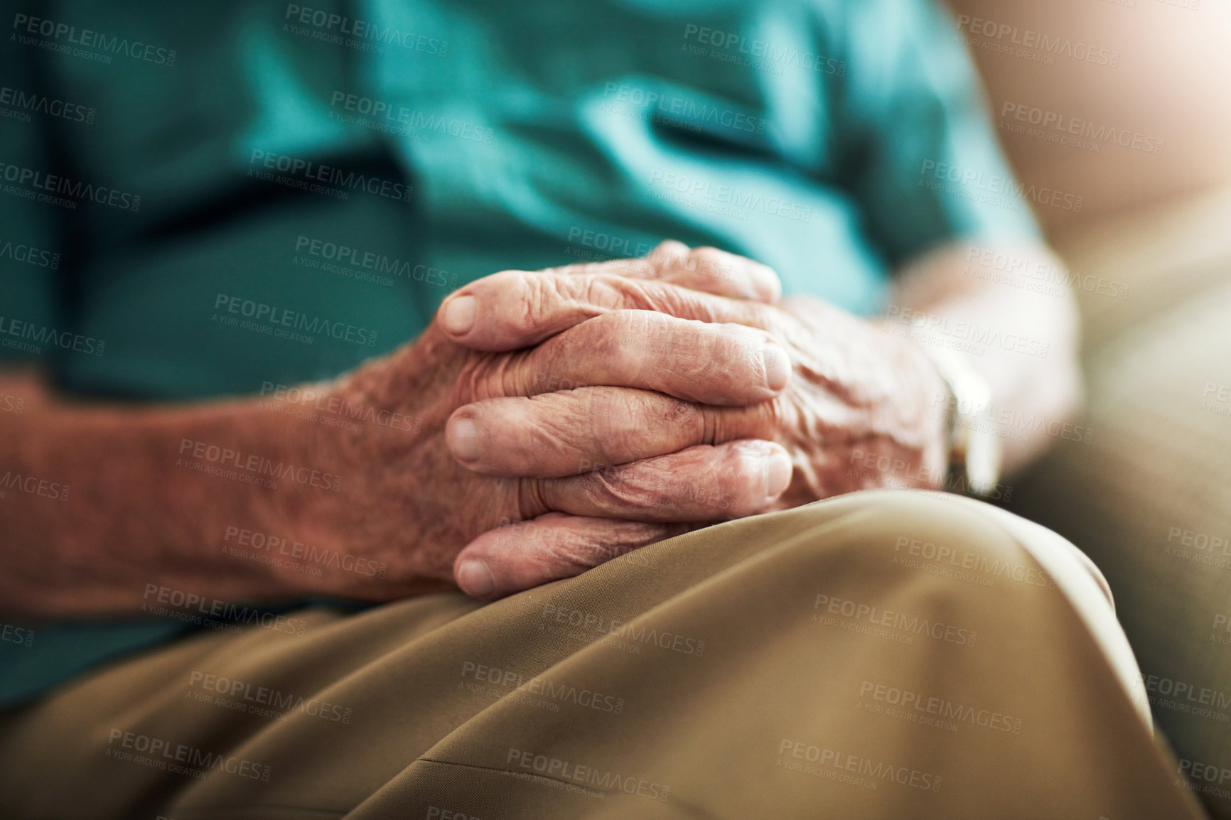 Buy stock photo Cropped shot of an unrecognizable senior male sitting with his hands on his knee indoors