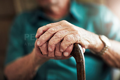 Buy stock photo Cropped shot of an unrecognizable man leaning on his walking stick