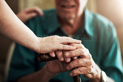 Buy stock photo Cropped shot of an unrecognizable female nurse assisting her senior patient who's using a wooden cane for support