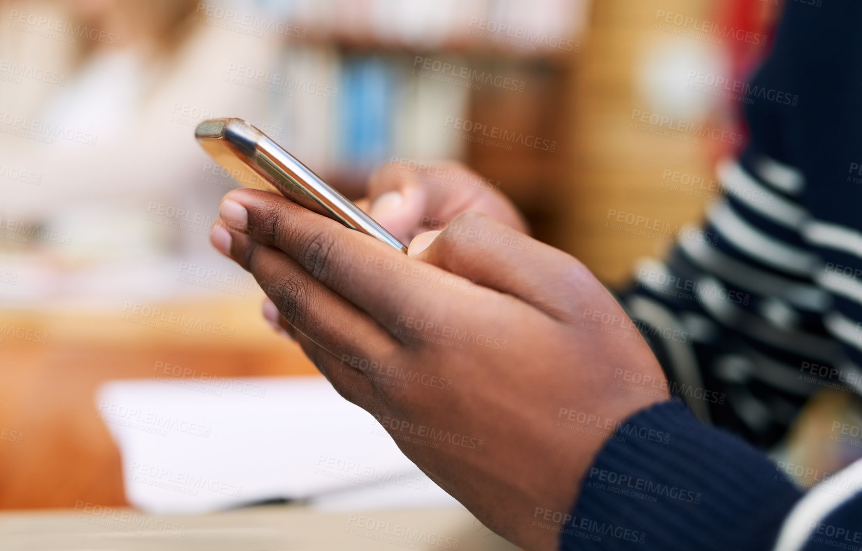 Buy stock photo Cropped shot of an unrecognizable student using his cellphone