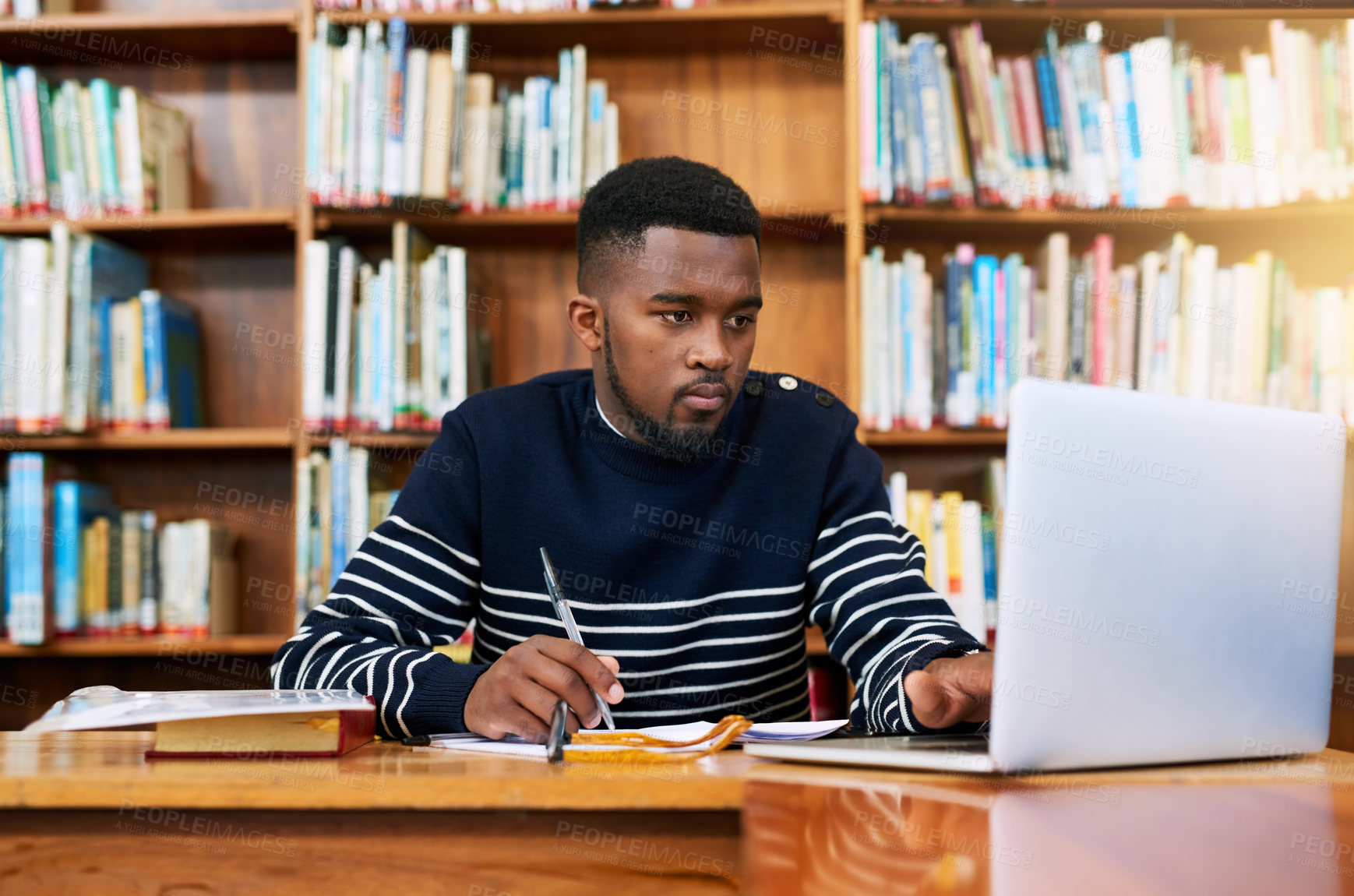 Buy stock photo University. library and student on laptop with research, planning or learning for exam, report or focus on studying, goals and education. Black man, college and working on task, essay or scholarship