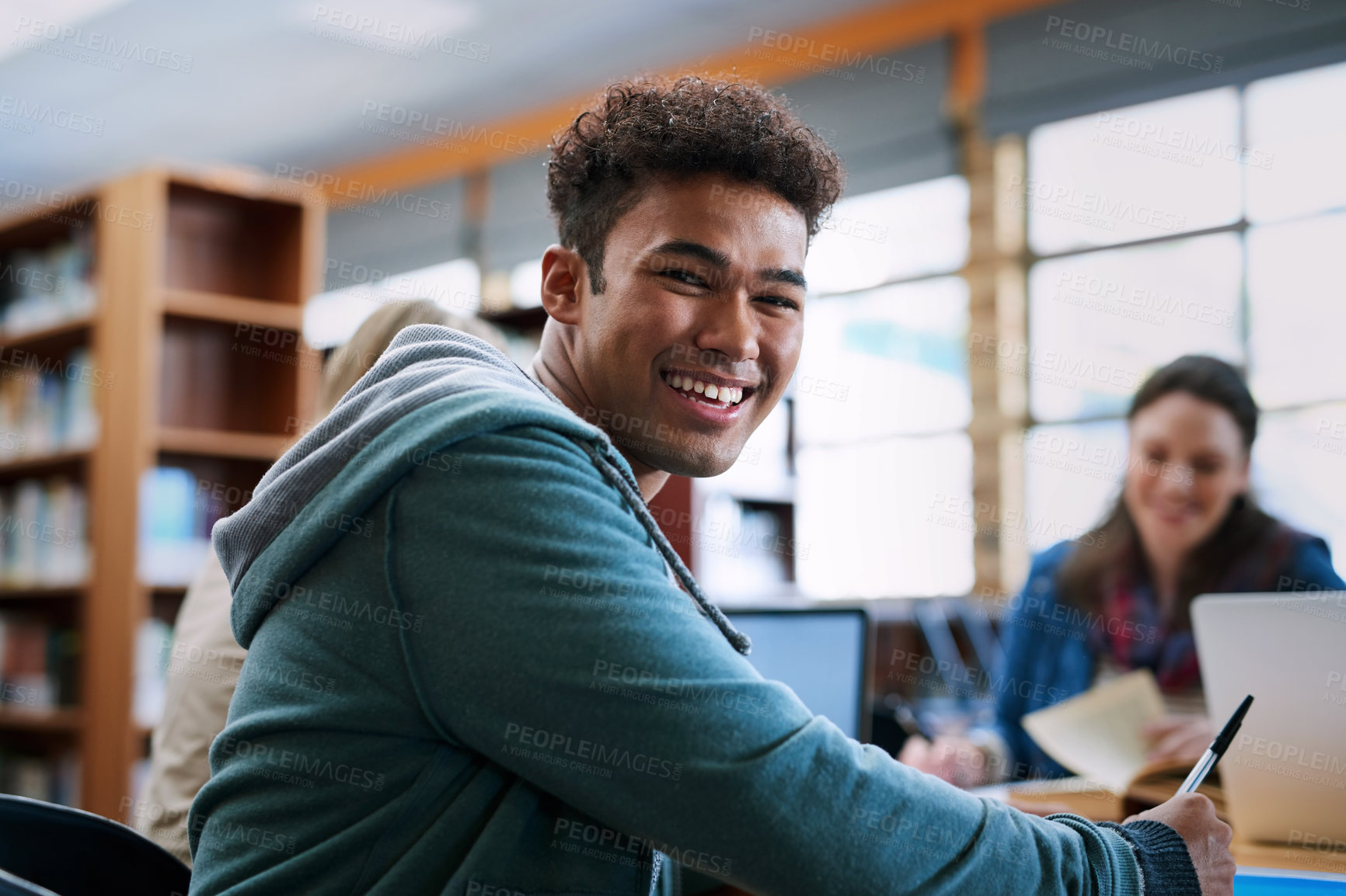 Buy stock photo University student, man and happy with portrait in library for writing, scholarship and studying for exam knowledge. Gen z, person and smile for learning, education and research notes for assessment